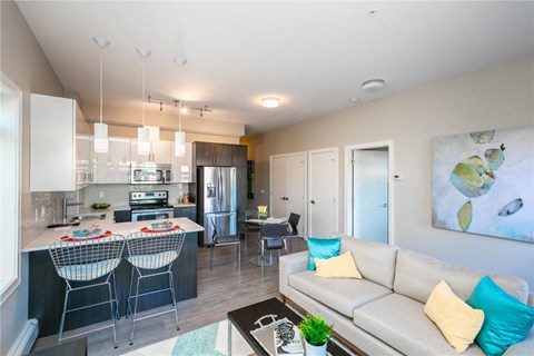 a living room and kitchen with a couch and a table